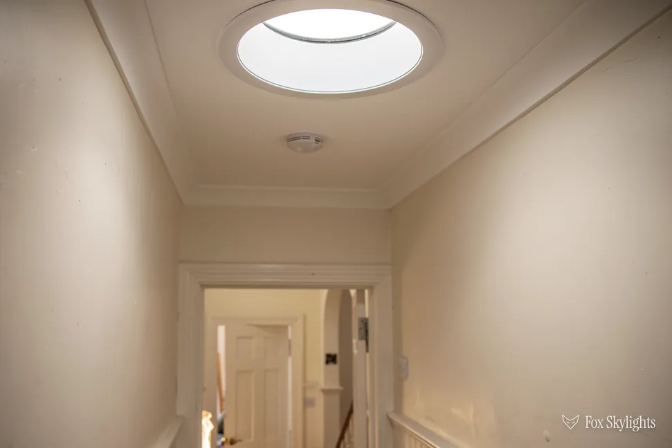 Round sun tunnel diffuser brightening a hallway ceiling