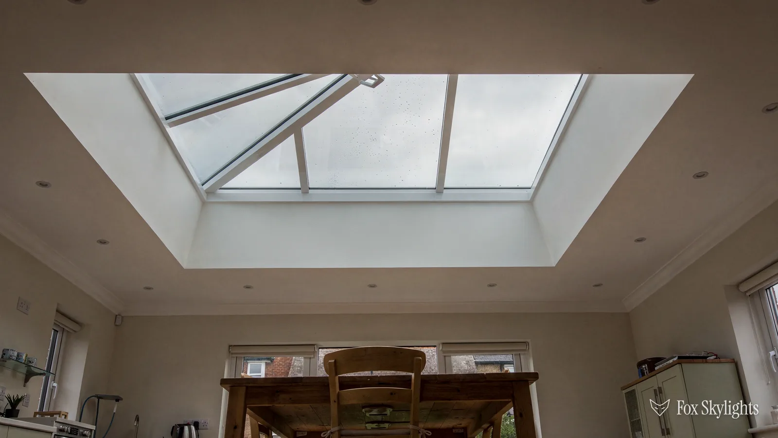 Wide roof lantern above an open plan room with dining table