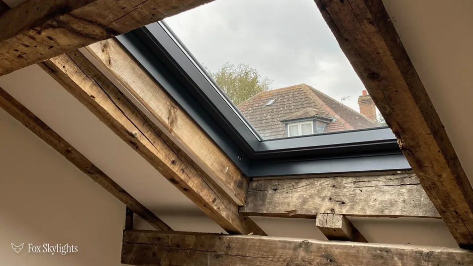 Slim rooflight fitted between old exposed timber rafters