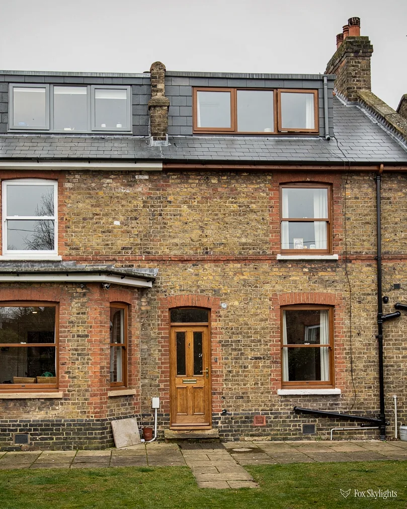 Yellow brick Victorian house with dormer windows in its slate roof