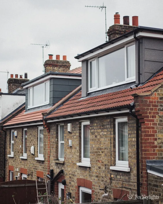 Brick terraced houses with dormer windows on a steep street