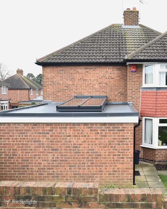 Brick semi with a flat rooflight on a single storey brick extension