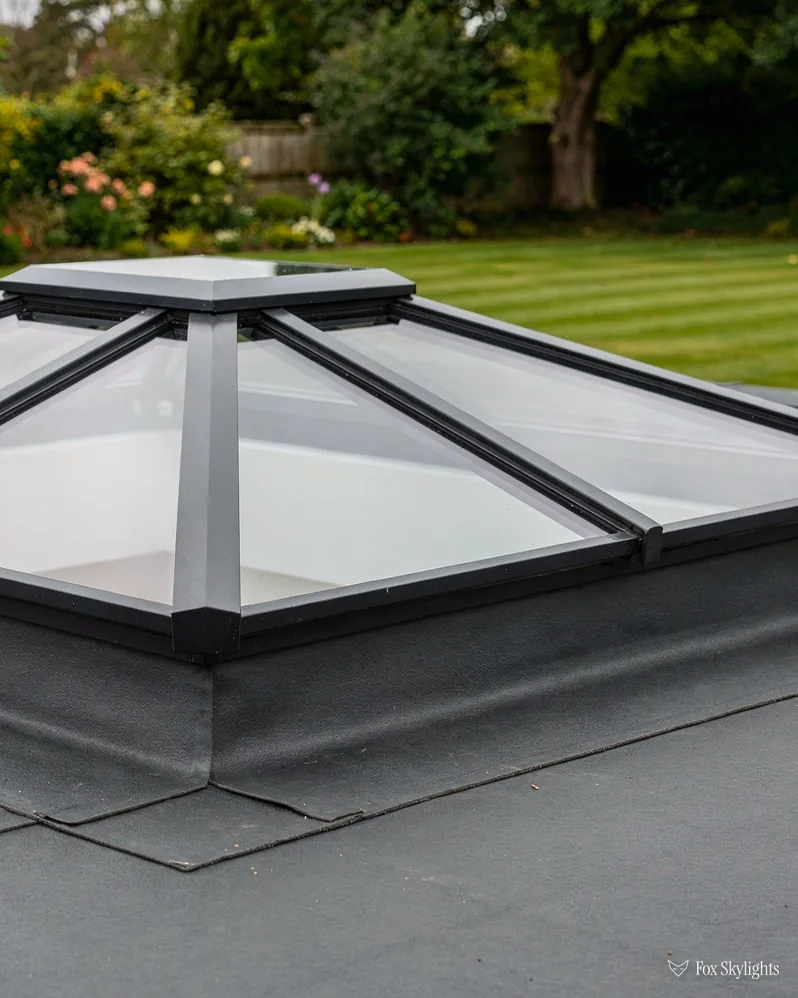 Roof lantern on a membrane flat roof overlooking a striped lawn and trees